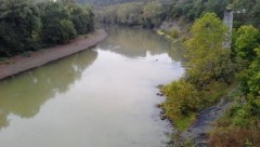 Photo of a muddy-looking river from the top of a bridge.