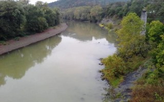 Photo of a muddy-looking river from the top of a bridge.