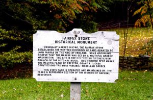 A white, aged plaque that tells the story of Fairfax Stone. 