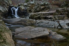 A small waterfall in the background leads to stream pools in the foreground.