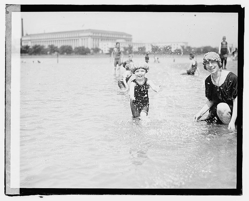 A child splashes water next to his mother in the tidal basin.