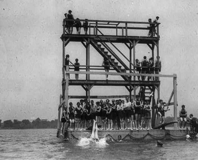 Swimmers jump from a large structure in the Potomac River in Washington, D.C.