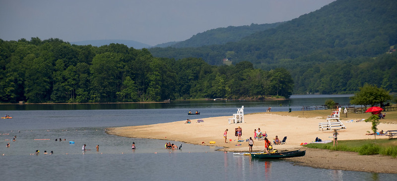 People play on a sandy beach along Lake Habeeb at Rocky Gap State Park.